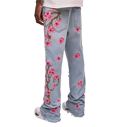 Light blue jeans with pink floral embroidery on a white background